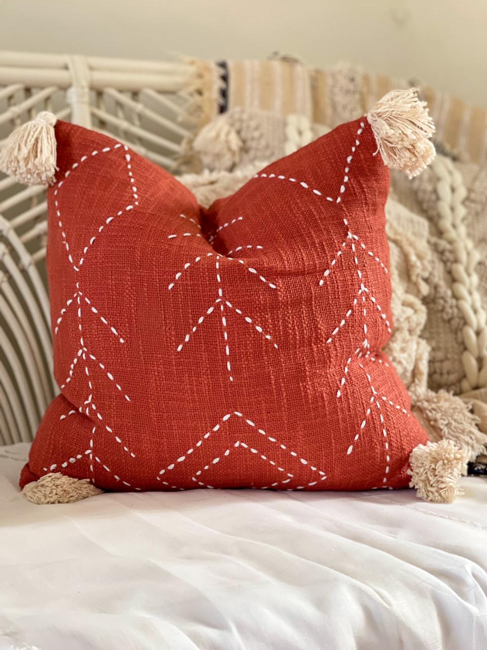 red cotton cushion with embroidered detail