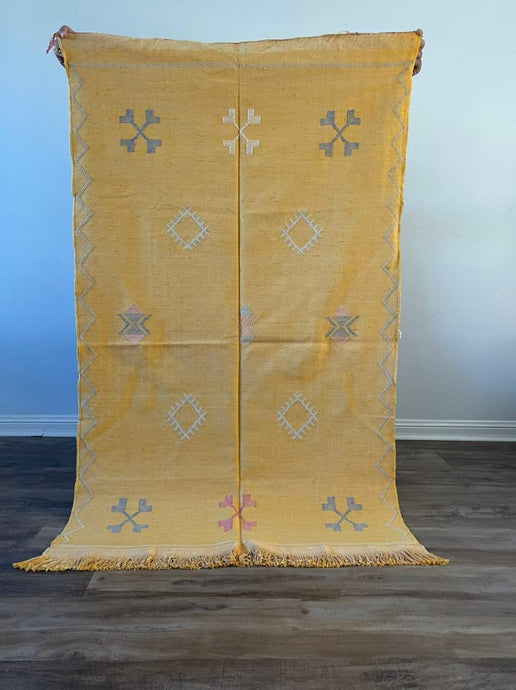 Yellow cactus silk rug with mutli coloured symbols woven into it